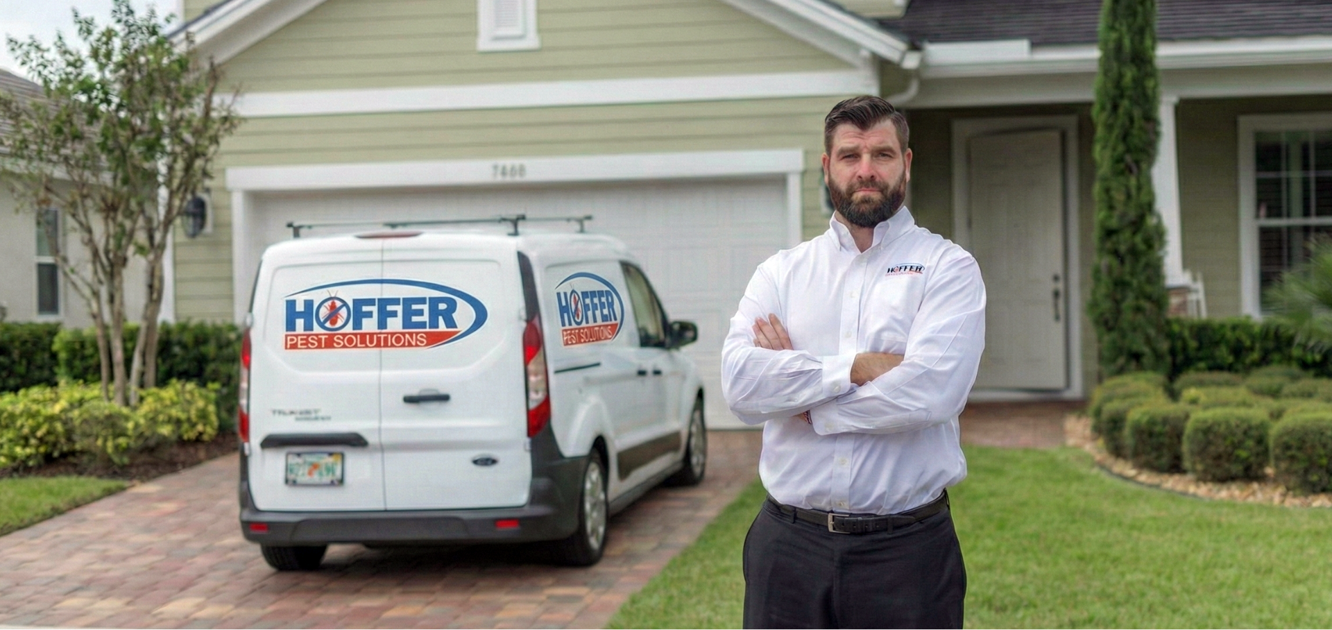 Man in Hoffer Pest Solutions shirt stands with arms crossed.