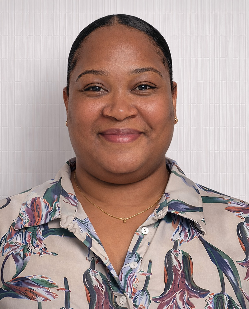 Woman with pulled-back hair smiles at the camera.
