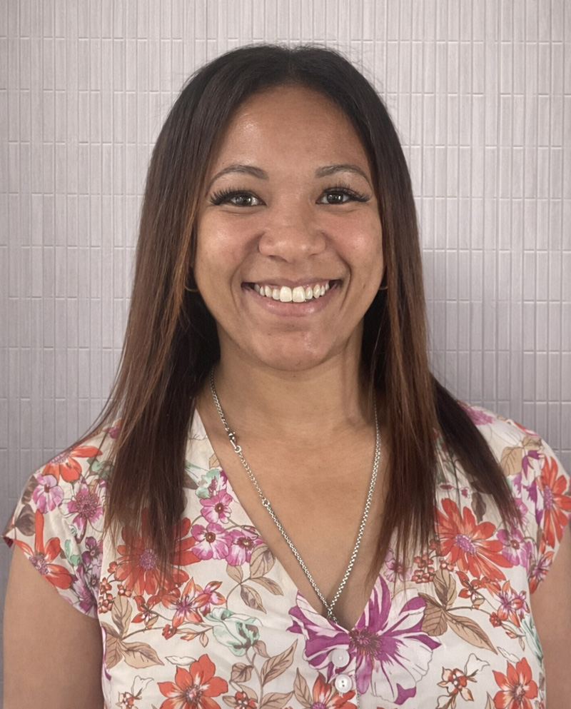 Woman with straight brown hair smiling at camera.