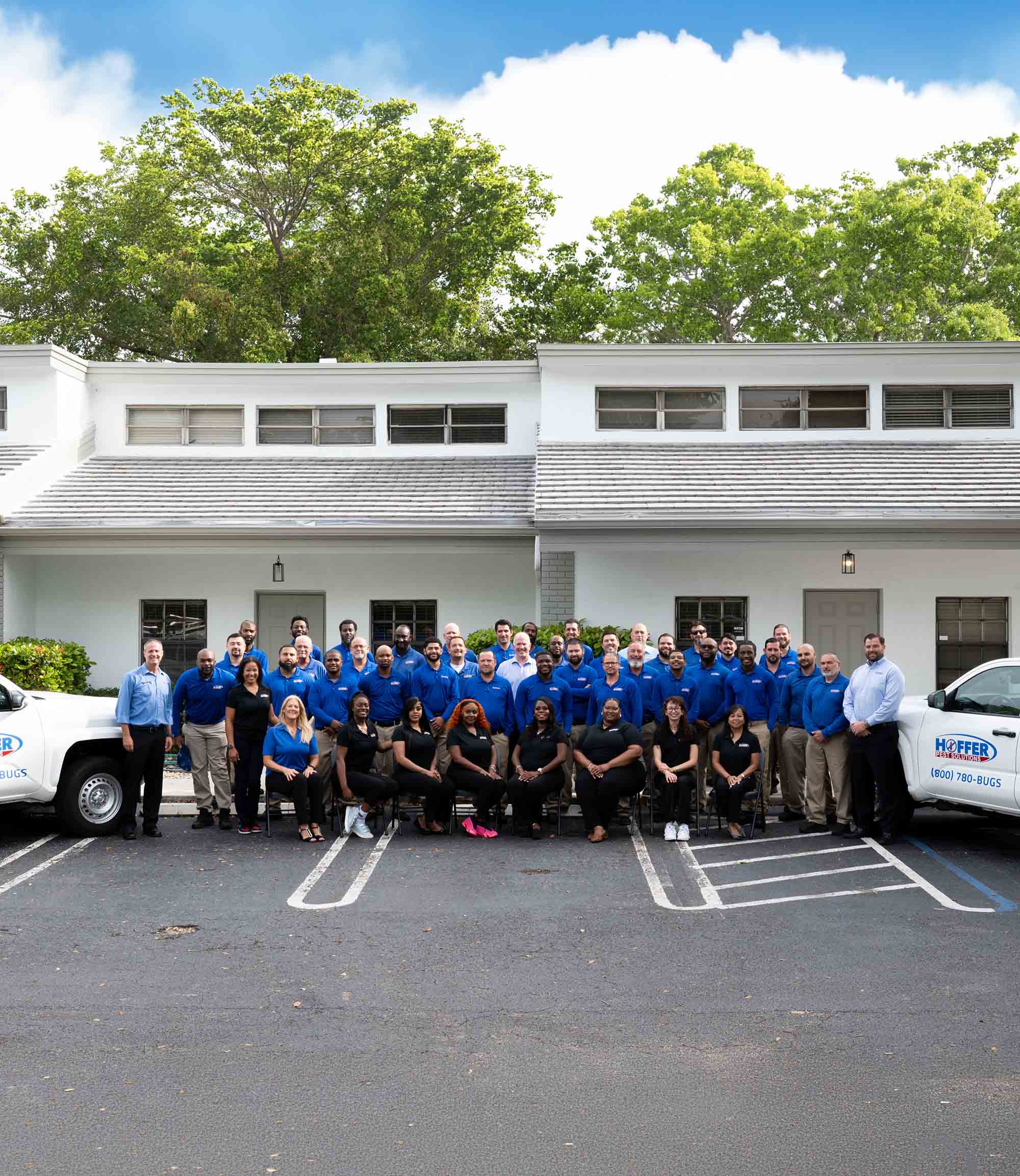Group of people stand together in front of building.