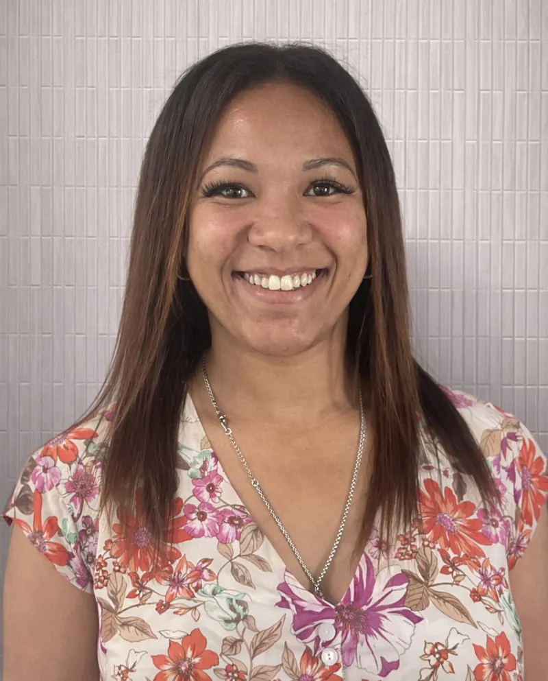 Woman with straight brown hair smiling at camera.